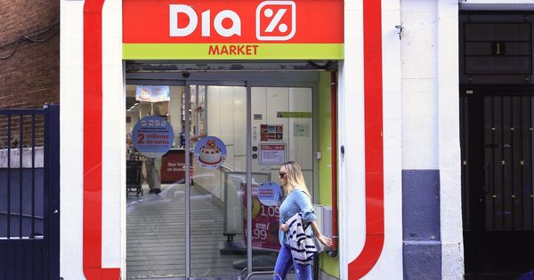 Foto: Una mujer pasa ante la puerta de un supermercado del Grupo DIA. (EFE)