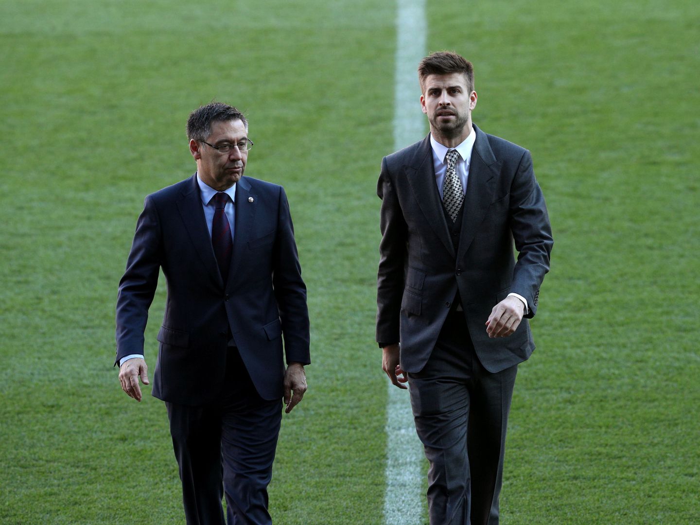 Josep María Bartomeu junto a Piqué en el césped del Camp Nou. (Efe)