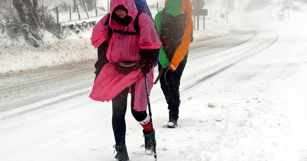 Foto: Peregrinos que recorren el Camino de Santiago llegan a O Cebreiro caminando con dificultad por la nieve. (EFE)