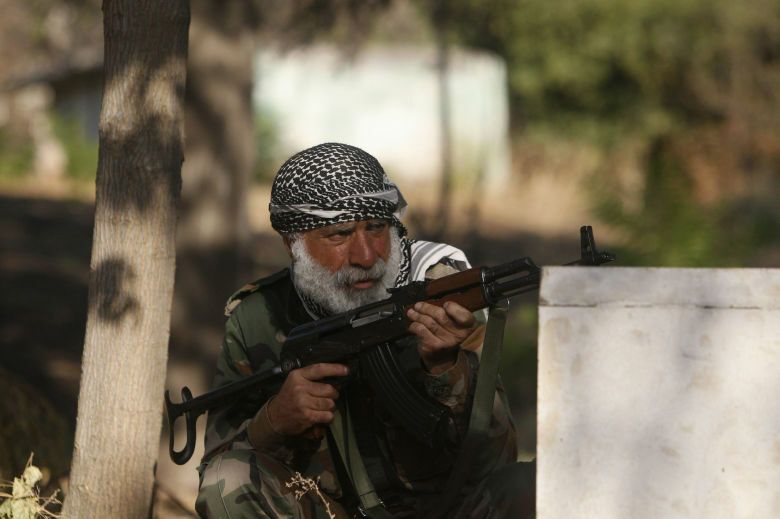 Un combatiente de una brigada que lucha junto al ejército de liberación sirio se pone a cubierto en alepo (reuters). 