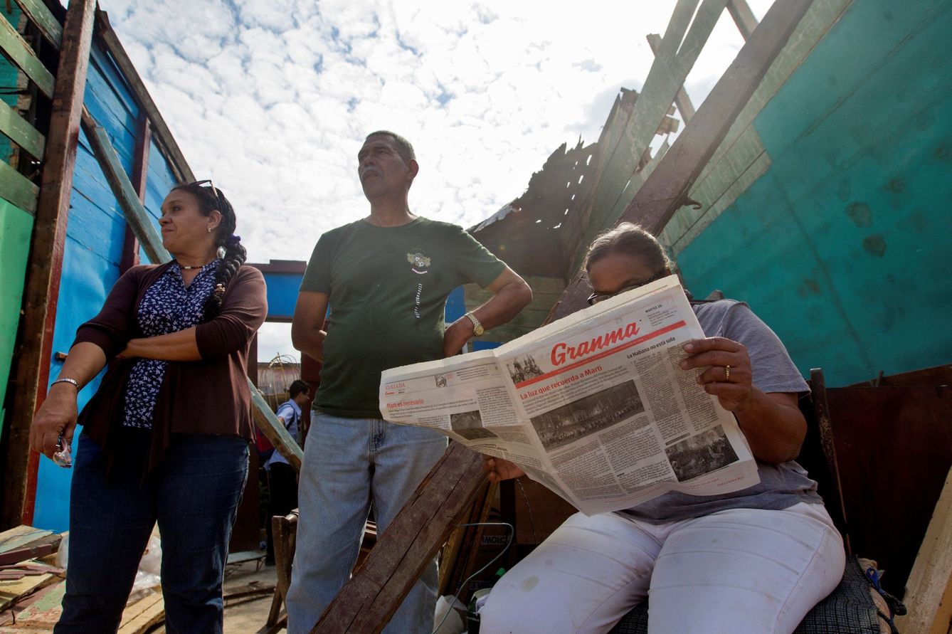 Una mujer lee el periódico 'Granma' tras el paso de un tornado por su casa en La Habana. (EFE)