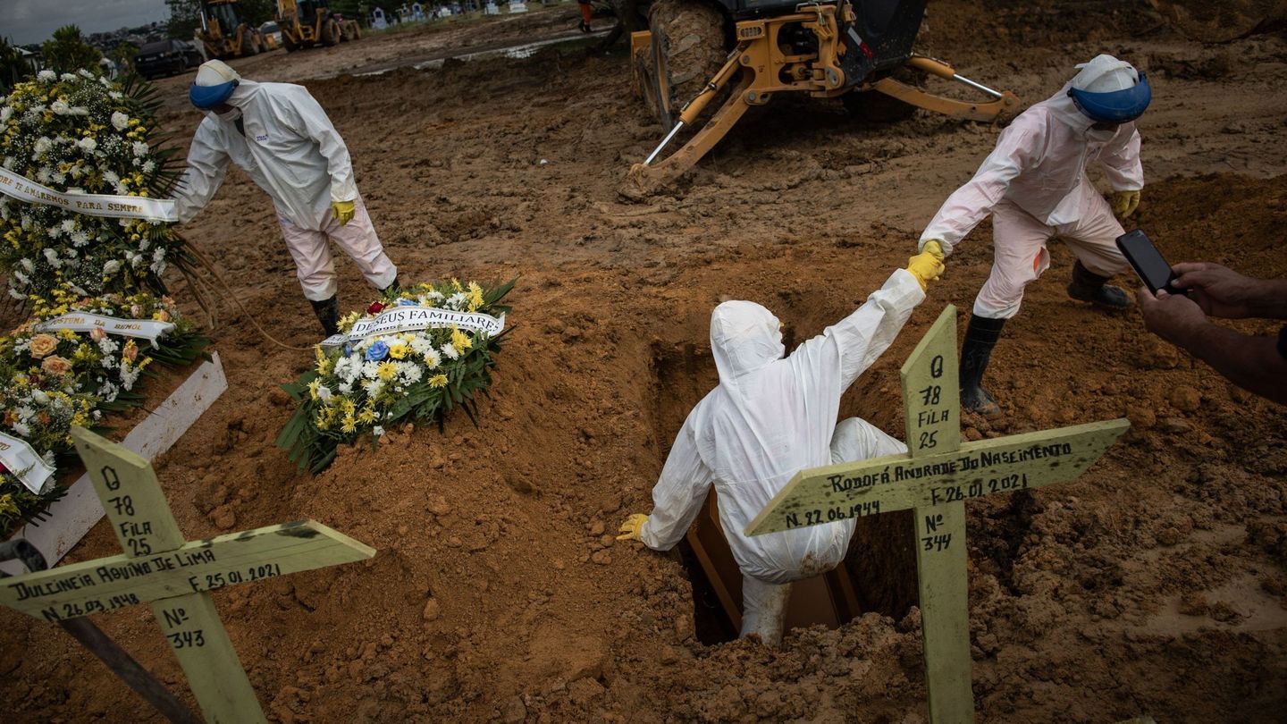 Trabajadores de un cementerio entierran a una persona fallecida por covid en Manaos. (EFE)