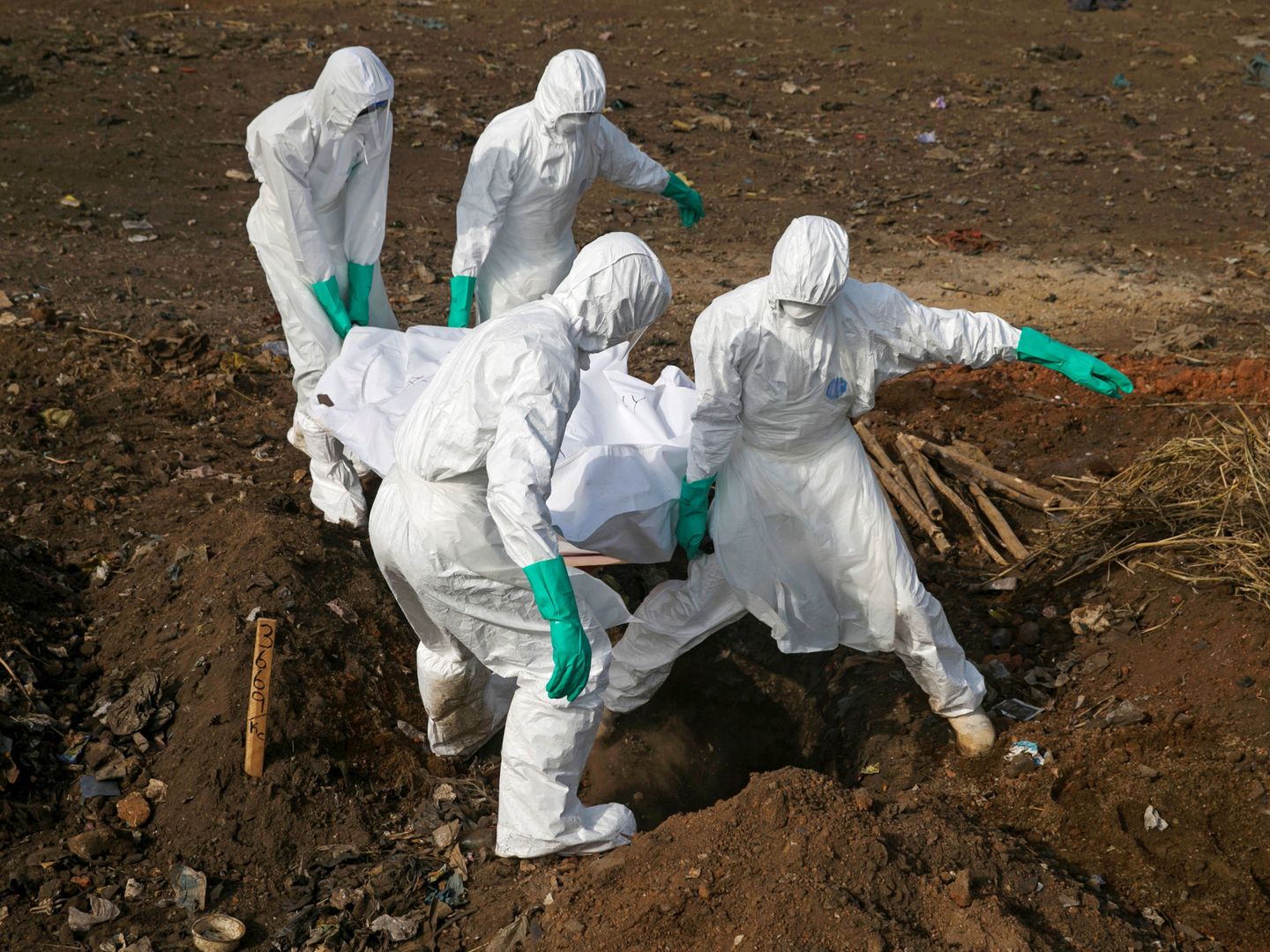 Trabajadores especializados transportan el cadáver de una supuesta víctima de ébola en Freetown, Sierra Leona, durante el brote de diciembre de 2014. (Reuters)