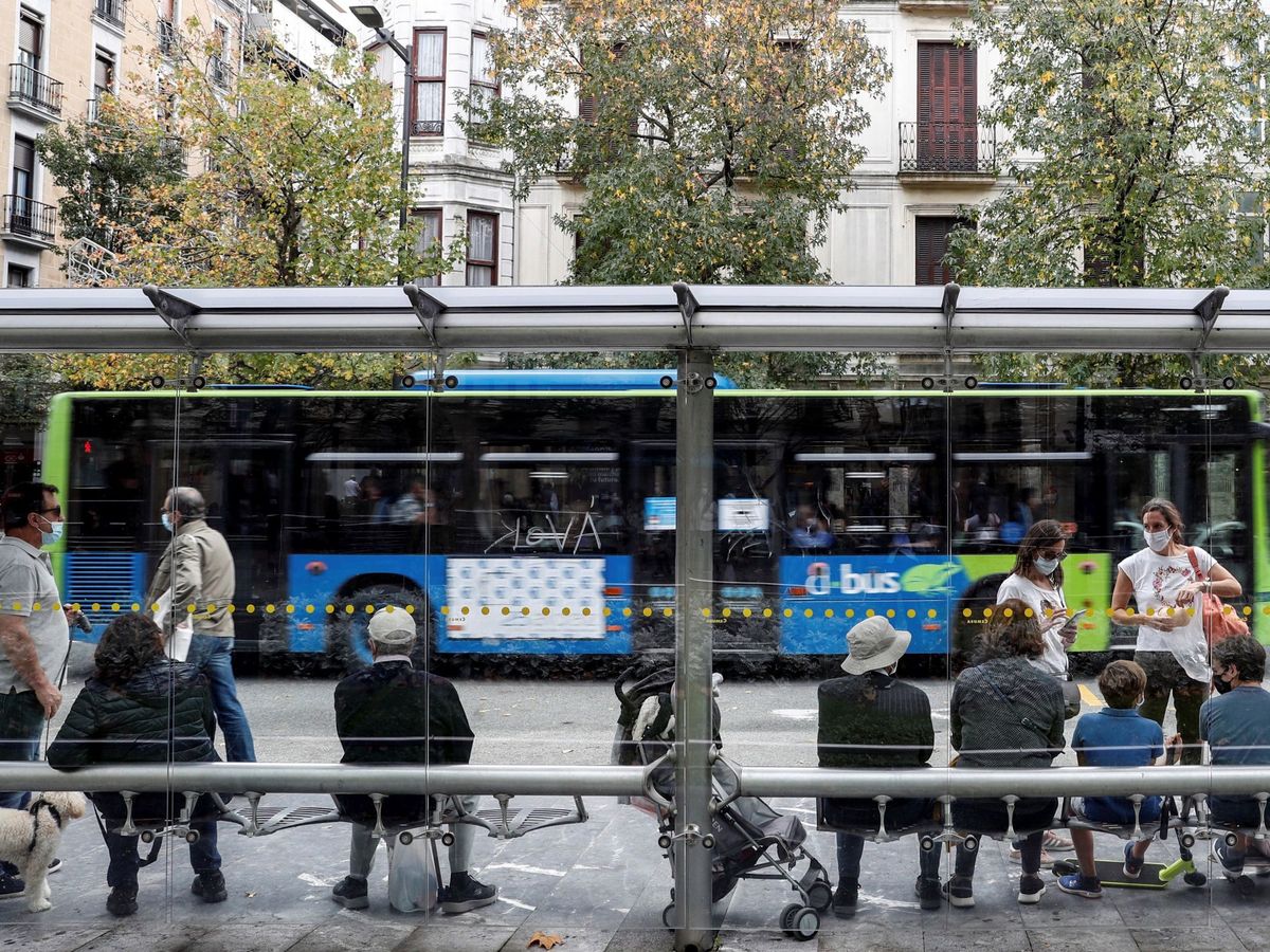 Foto: n grupo de personas espera en la parada de autobús de San Sebastián. (EFE)