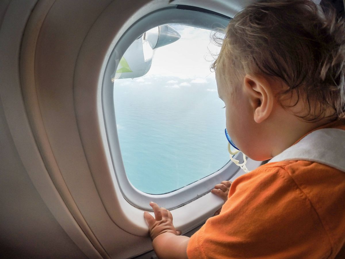 Foto: Un bebé se asoma a la ventanilla de un avión. (iStock)