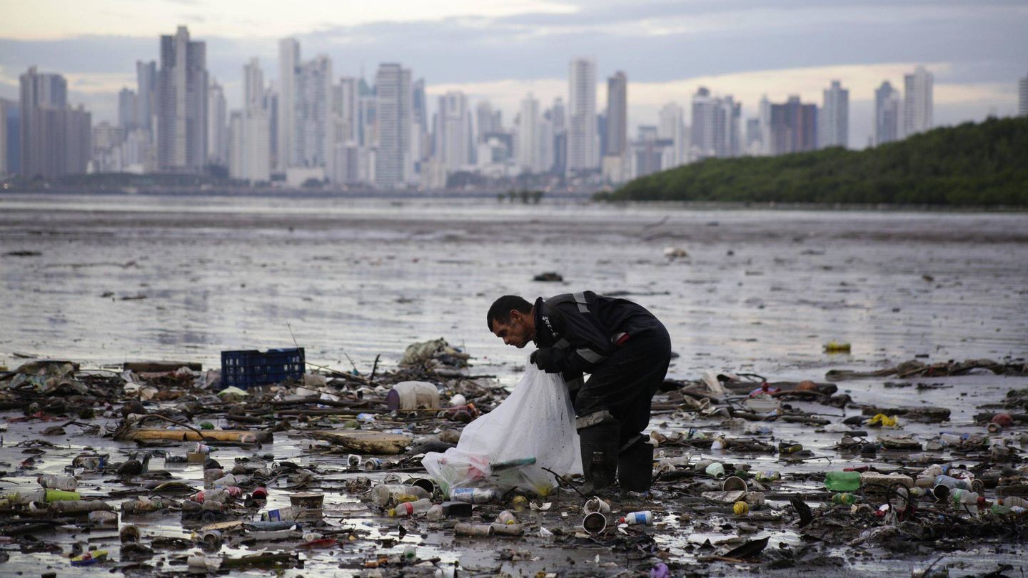 Un activista recoge desperdicios en la Bahía de Panamá en 2018 (EFE)