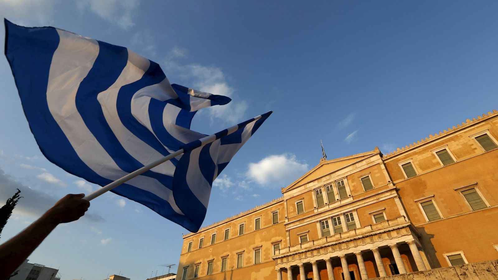 Foto: Un manifestante sostiene una bandera griega durante las protestas anti-austeridad en Atenas. (Reuters)