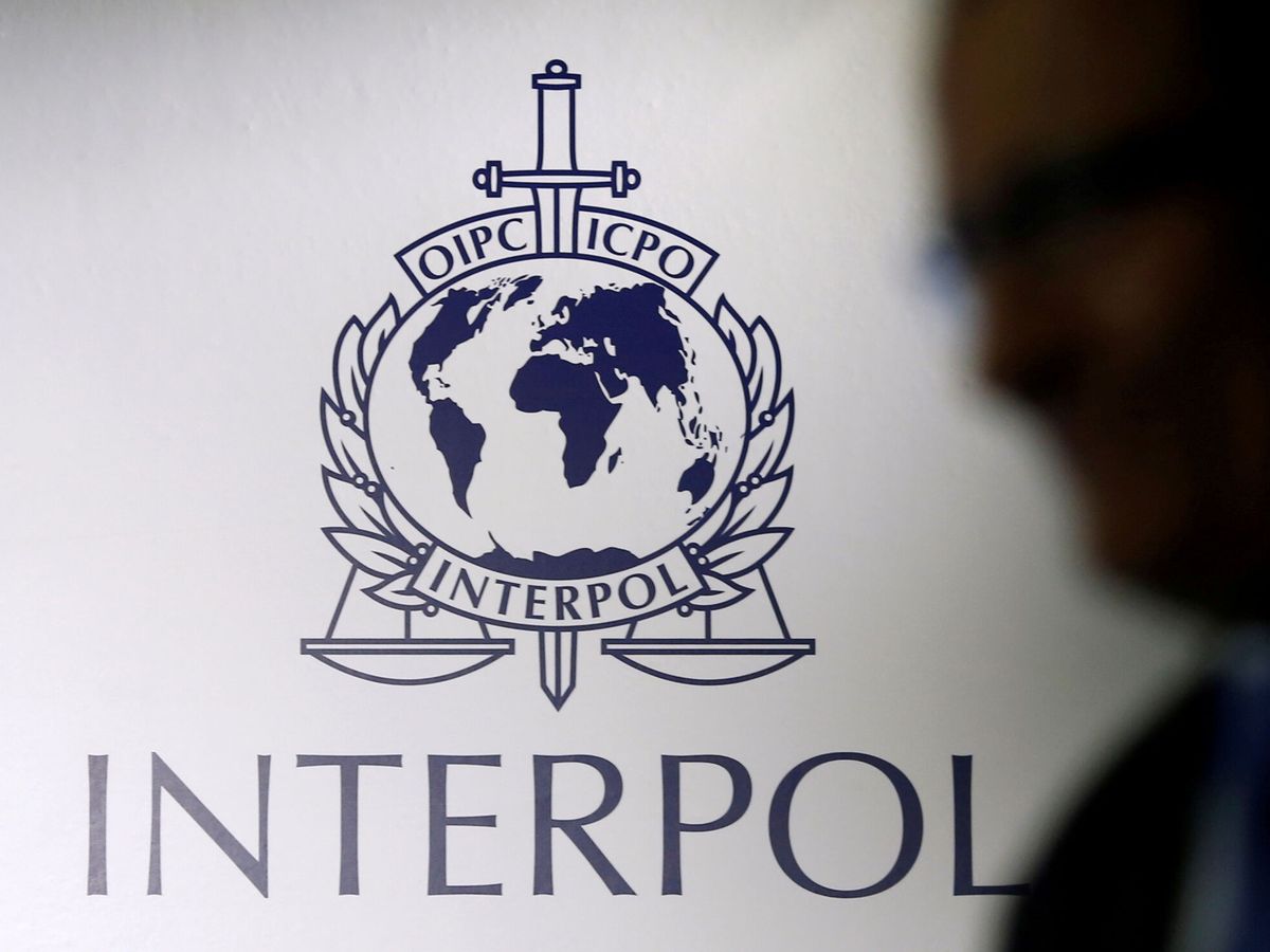 Foto: Un hombre pasa junto a un logotipo de Interpol. (Reuters) 