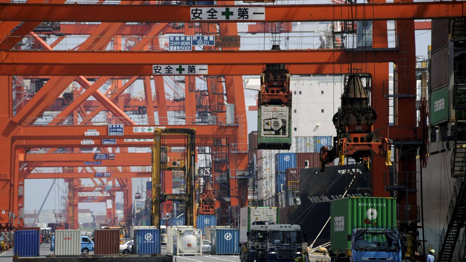 Foto: Trabajadores cargan contenedores en un barco carguero en un puerto de Tokio (Japón). (EFE)
