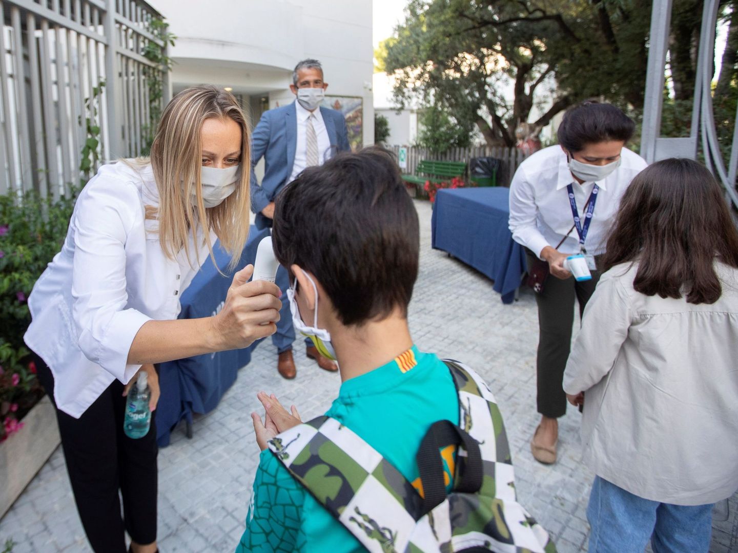 Una trabajadora toma la temperatura a un niño a la entrada del colegio privado internacional American School of Barcelona. (EFE)