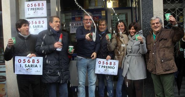 Foto: Los dueños y trabajadores de la Administración de Lotería de la Avenida Lehendakari Aguirre en Bilbao celebran haber vendido el Gordo del Niño. (EFE)