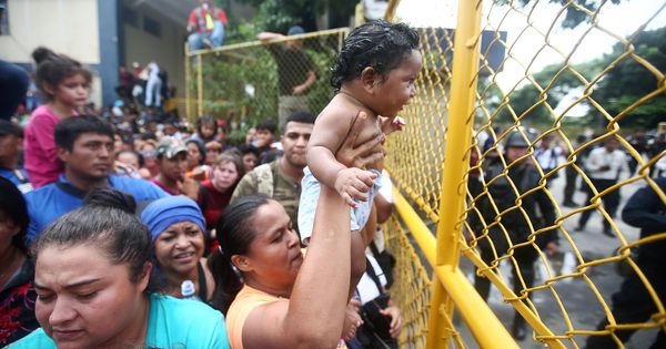 Foto: Una migrante hondureña sostiene a su bebé en la valla de la frontera entre Guatemala y México. (Retuers)