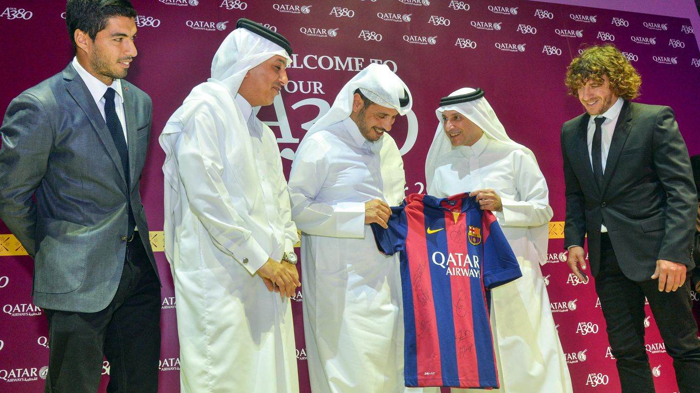 Luis Suárez y Carlos Puyol, con representantes de Qatar Airways, en un acto celebrado en Doha. (EFE)