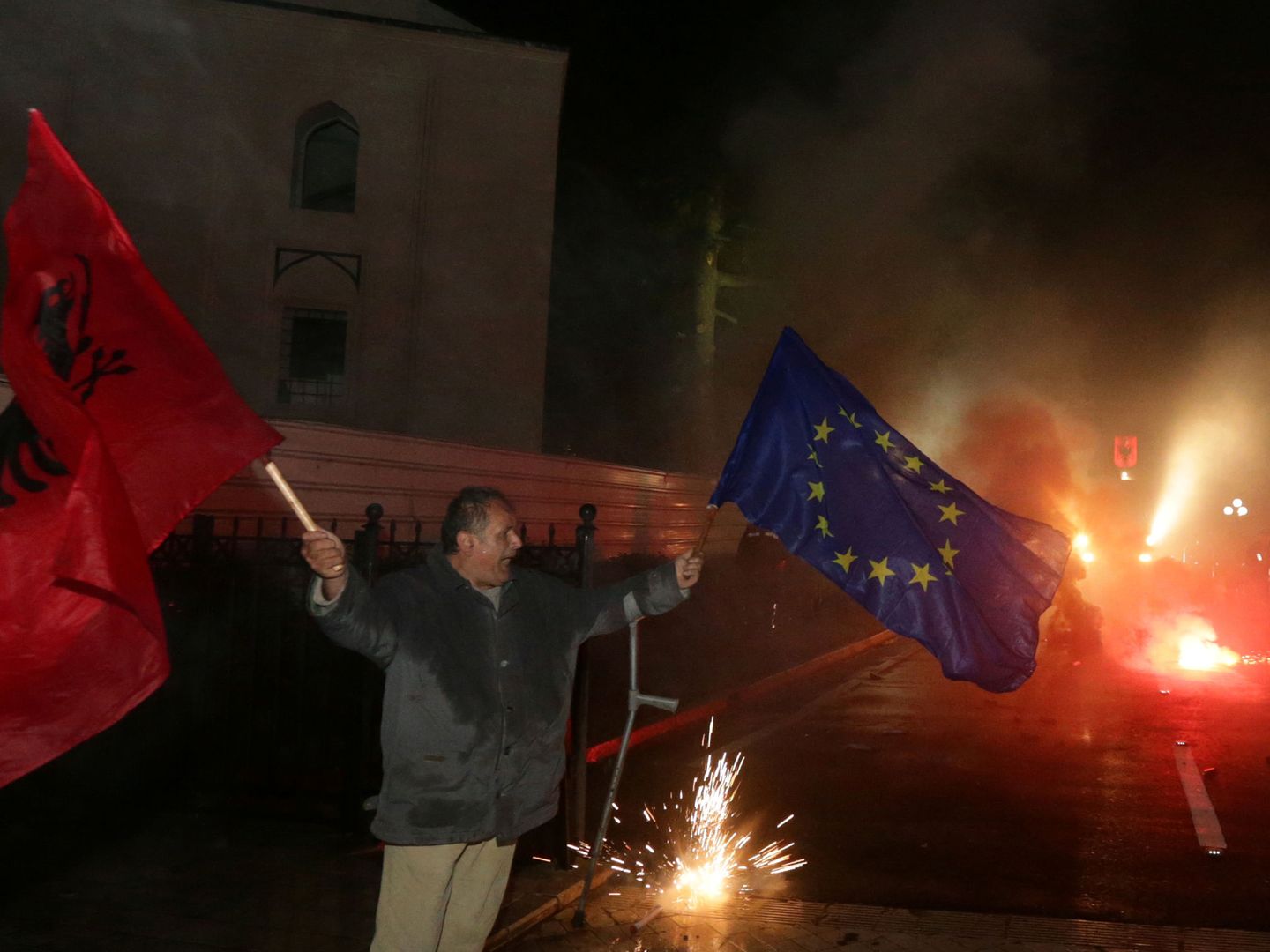 Un manifestante contra el Gobierno de Albania protesta con una bandera albanesa y otra europea. (Reuters)