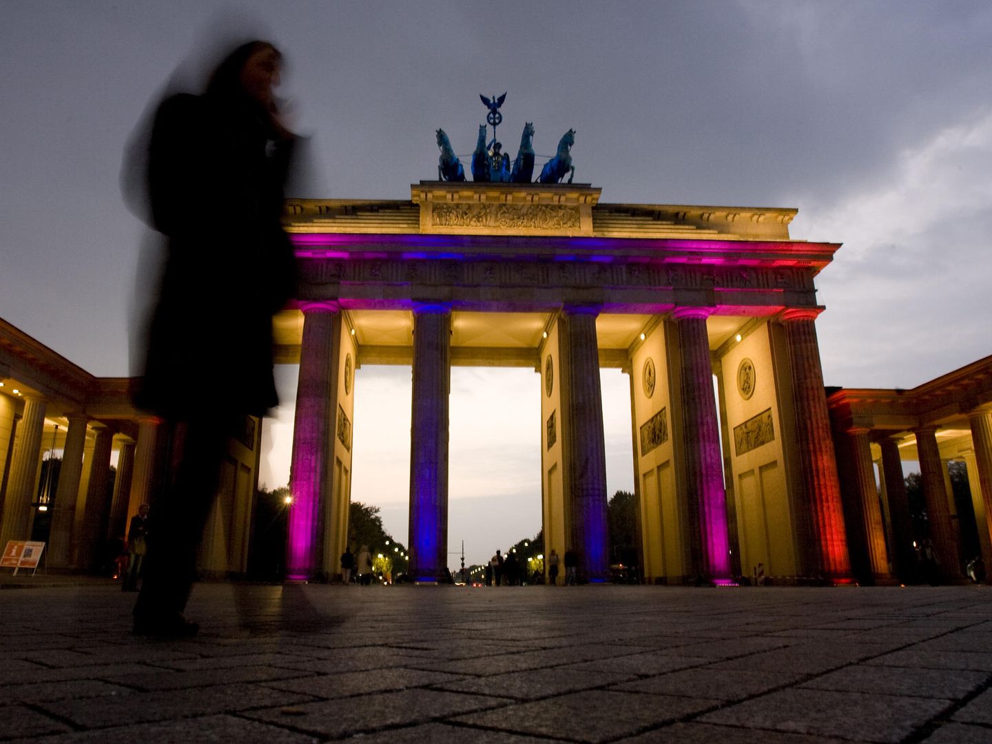 Una mujer pasa ante la puerta de Branderburgo iluminada durante el 'Festival de las luces' que Berlín celebra cada octubre (Reuters). 