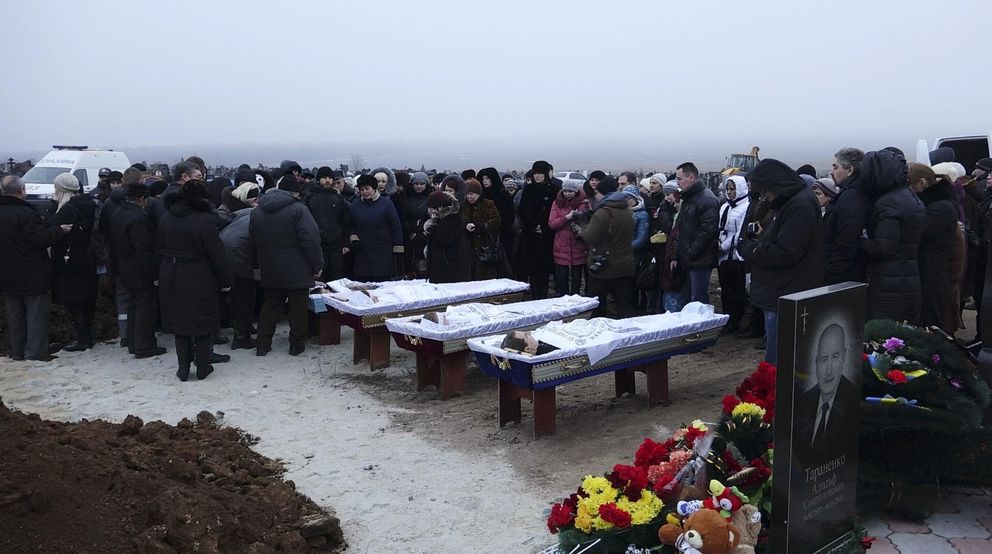 Ucranianos asisten a los funerales de civiles muertos por fuego de mortero en Mariupol (Reuters).
