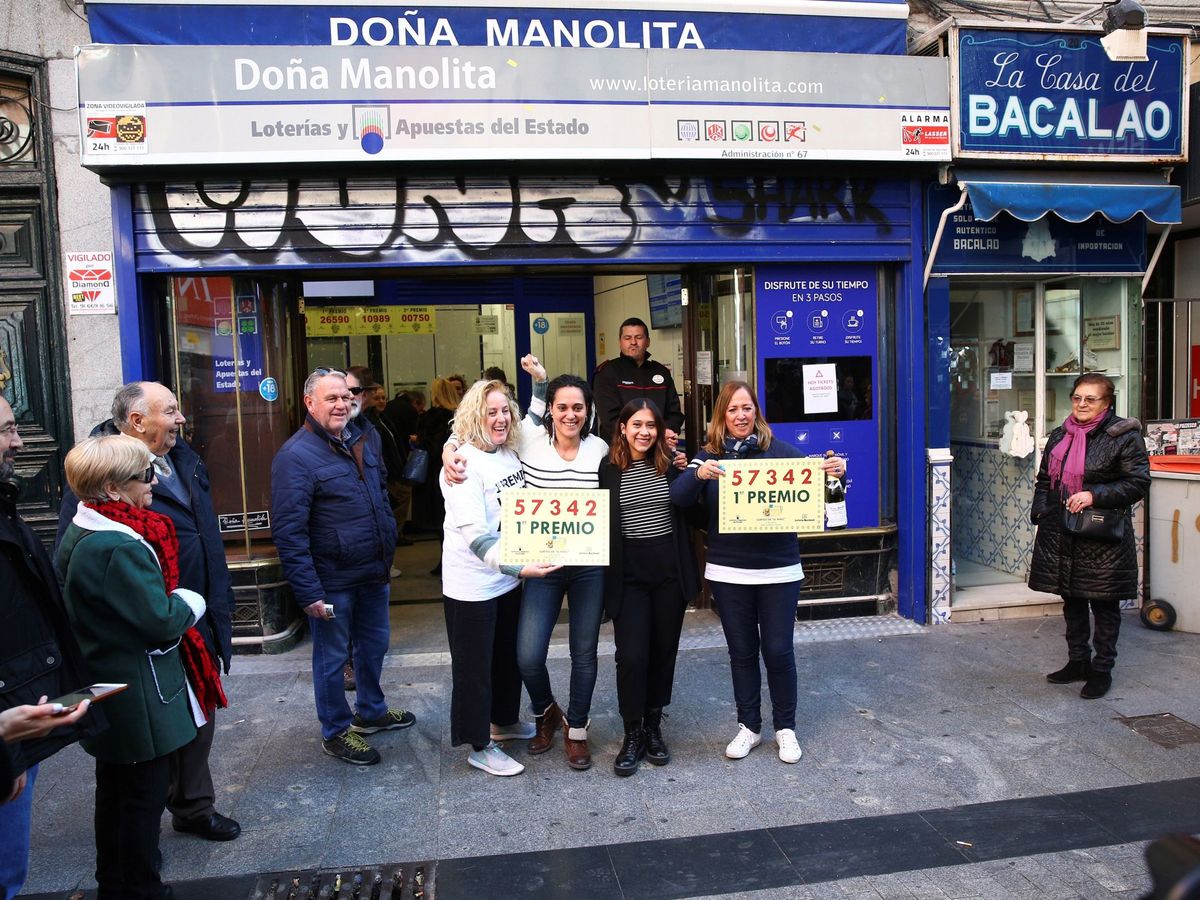 Foto: Un grupo de personas celebra el primer premio en la administración de Lotería Doña Manolita (EFE)
