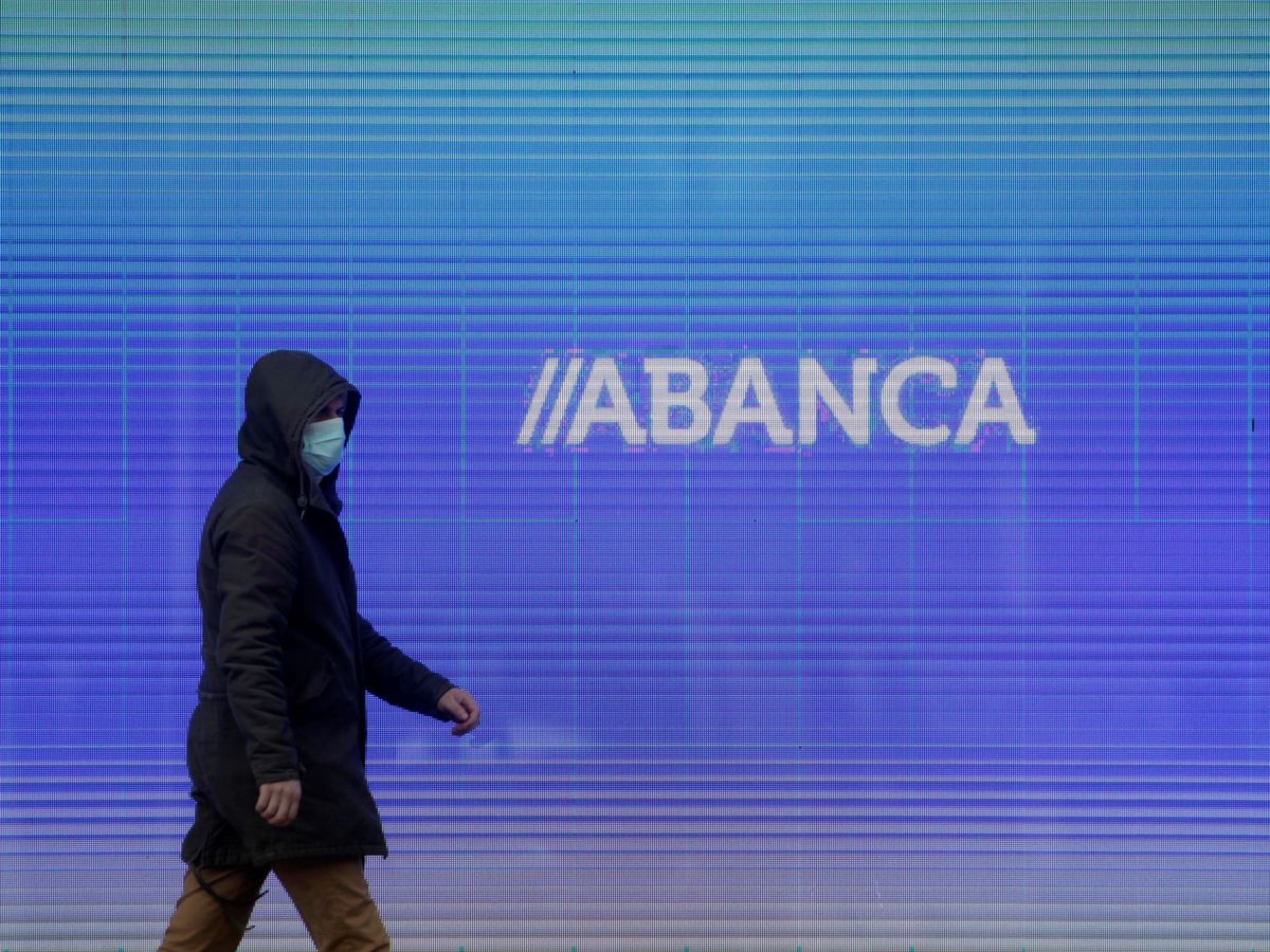 Foto: Un hombre camina frente a la sede central de Abanca en A Coruña. (EFE)