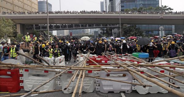 Foto: Varios manifestantes permanecen tras una barricada durante una marcha contra el Gobierno en Hong Kong (China). (EFE)