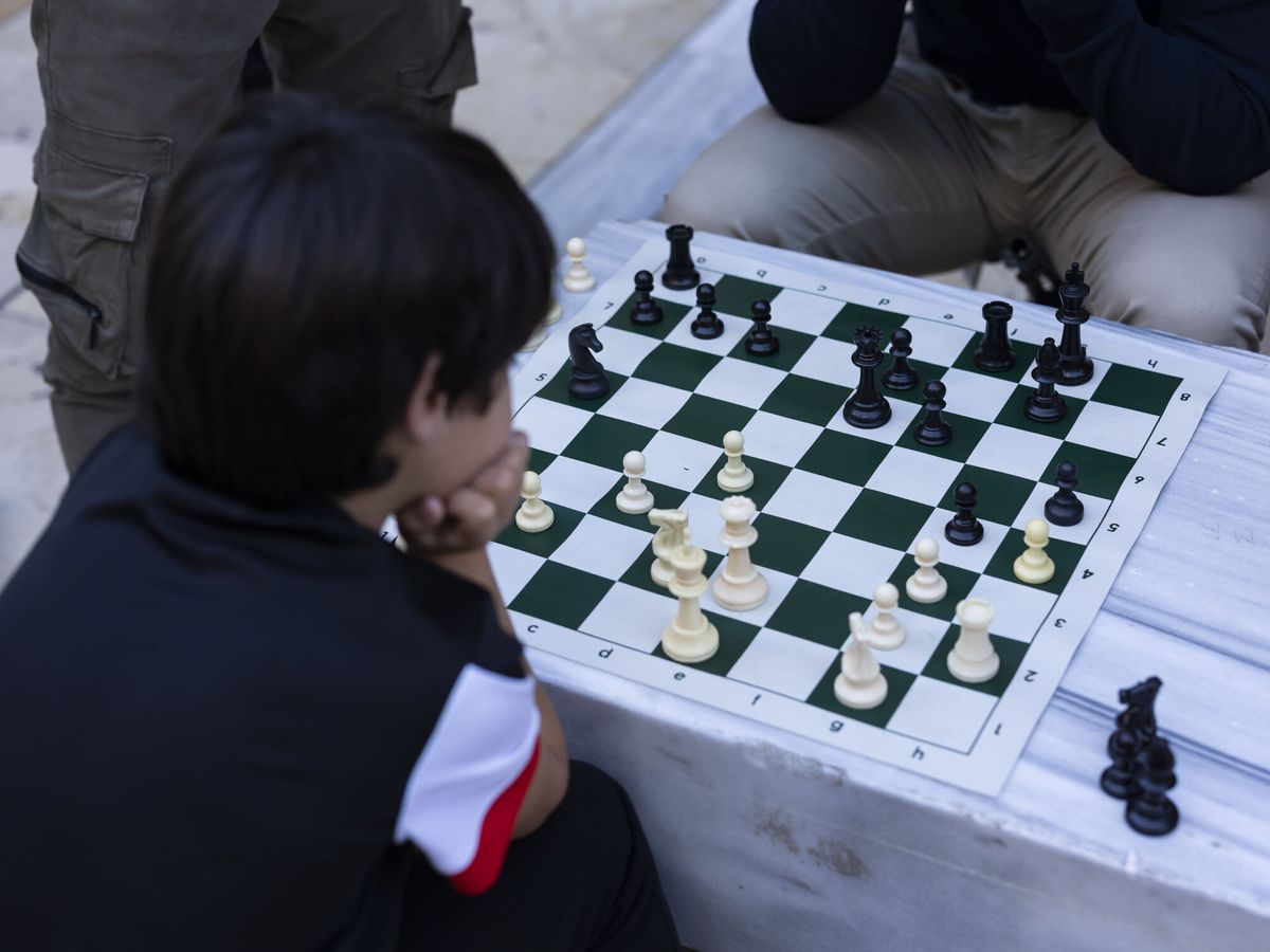 Foto: Un joven malagueño juega al ajedrez en la calle Larios. (EFE/Carlos Díaz)
