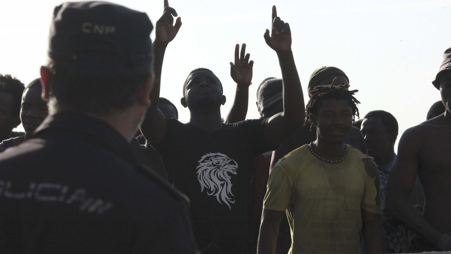 Agentes de la Policía Nacional custodian a inmigrantes subsaharianos. (EFE)
