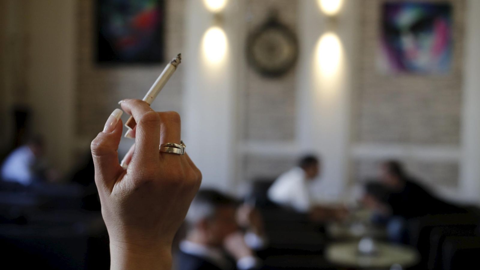 Foto: Mujer sostiene un cigarrillo en un café de Viena (Leonhard Foeger / Reuters)