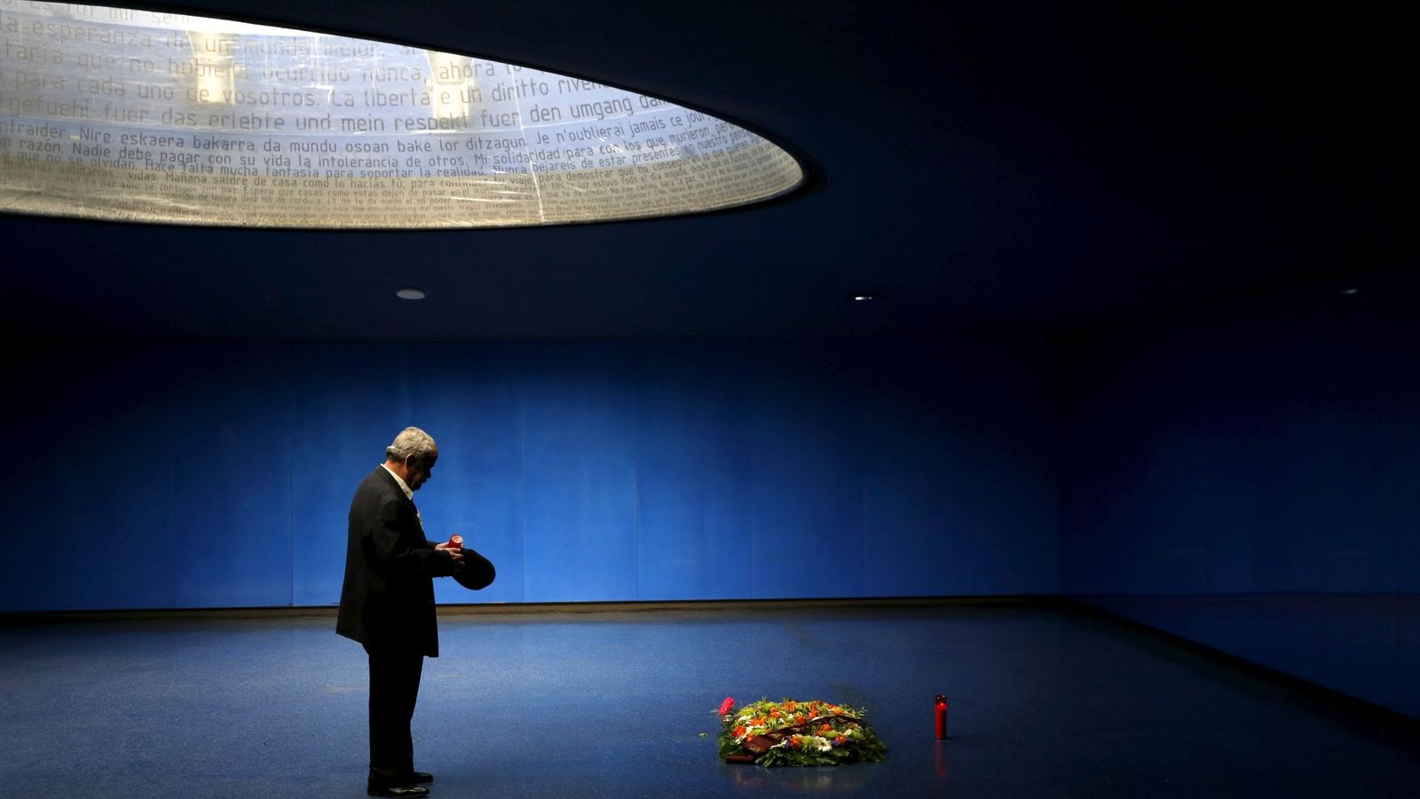 Foto: Un hombre enciende una vela en el monumento a las víctimas del 11-M. (Reuters)