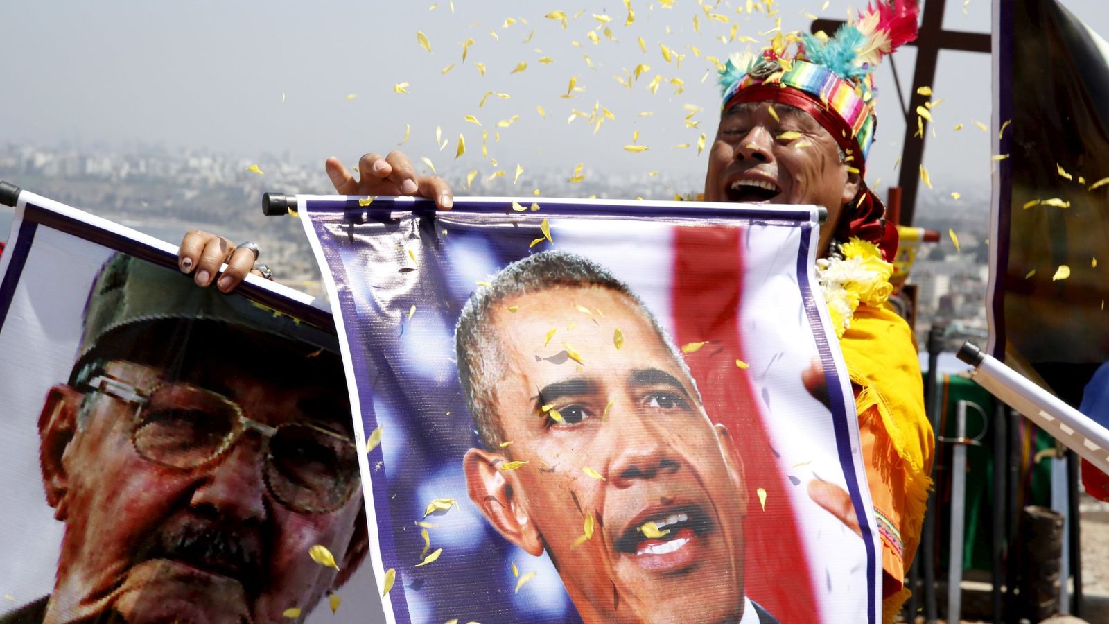 Foto: Un chamán peruano sostiene imágenes de Raúl Castro y Barack Obama durante un ritual de paz en Chorrillos, Lima, el 29 de diciembre de 2015 (Reuters)