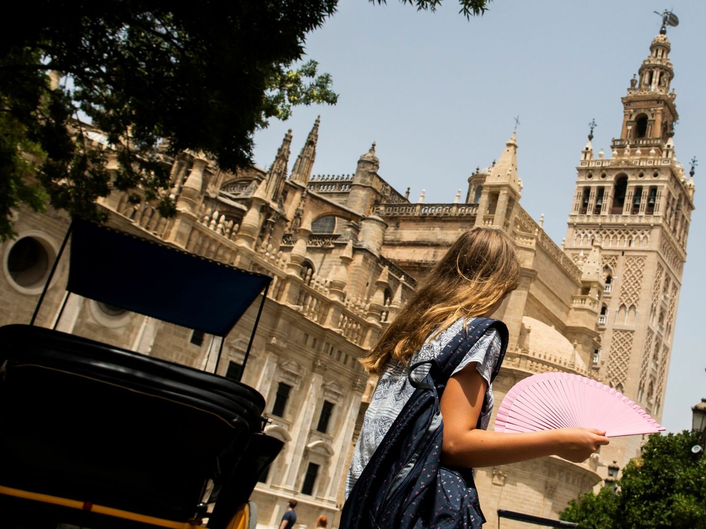 Una mujer se abanica en los aledaños de la Catedral de Sevilla (EFE)