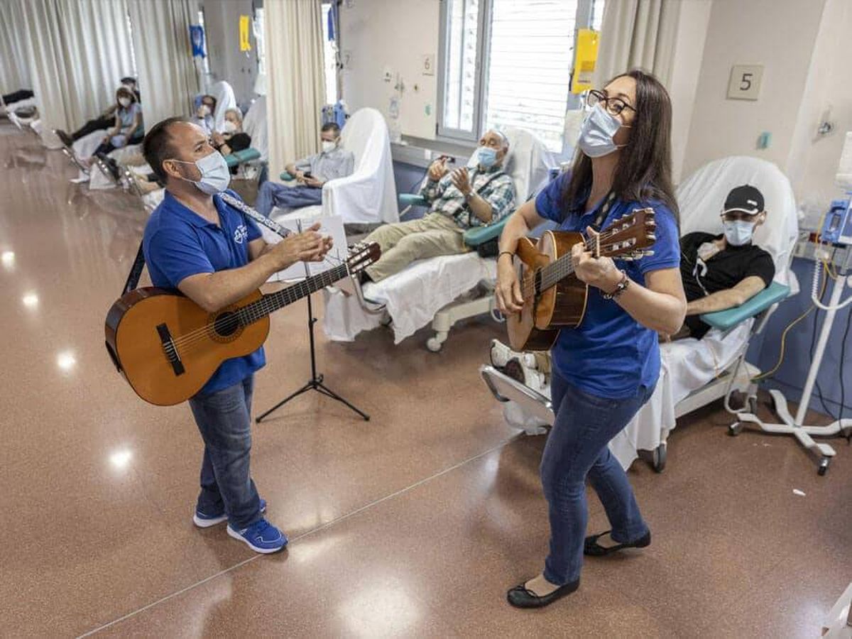 Foto: Juanjo Pérez y Gabriela Castillo tocan ante varios pacientes. (Ana Palacios)