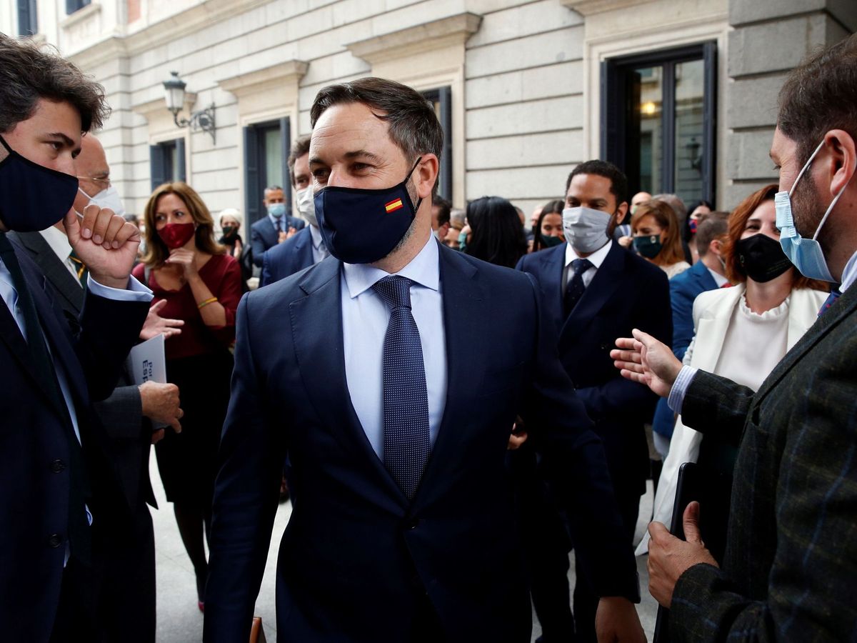 Foto: El líder de Vox, Santiago Abascal, arropado por diputados de su grupo en las afueras del Congreso. (EFE)