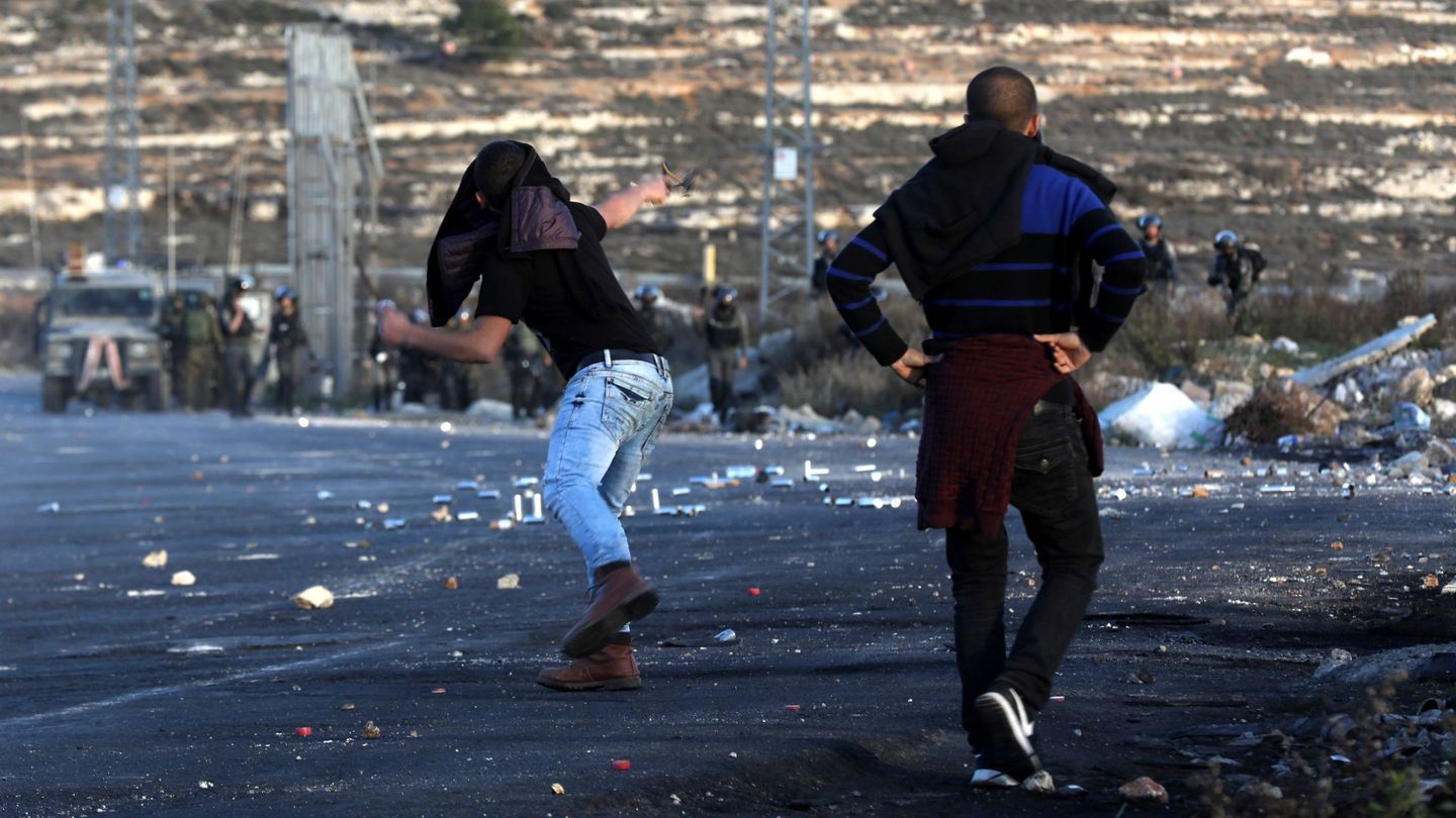 Palestinos arrojan piedras durante los enfrentamientos en Cijosrdania. (EFE)