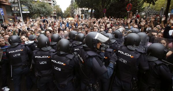 Foto: Agentes antidisturbios de la Policía Nacional forman un cordón de seguridad en los alrededores del colegio Ramón Llull de Barcelona el 1-O. (EFE)