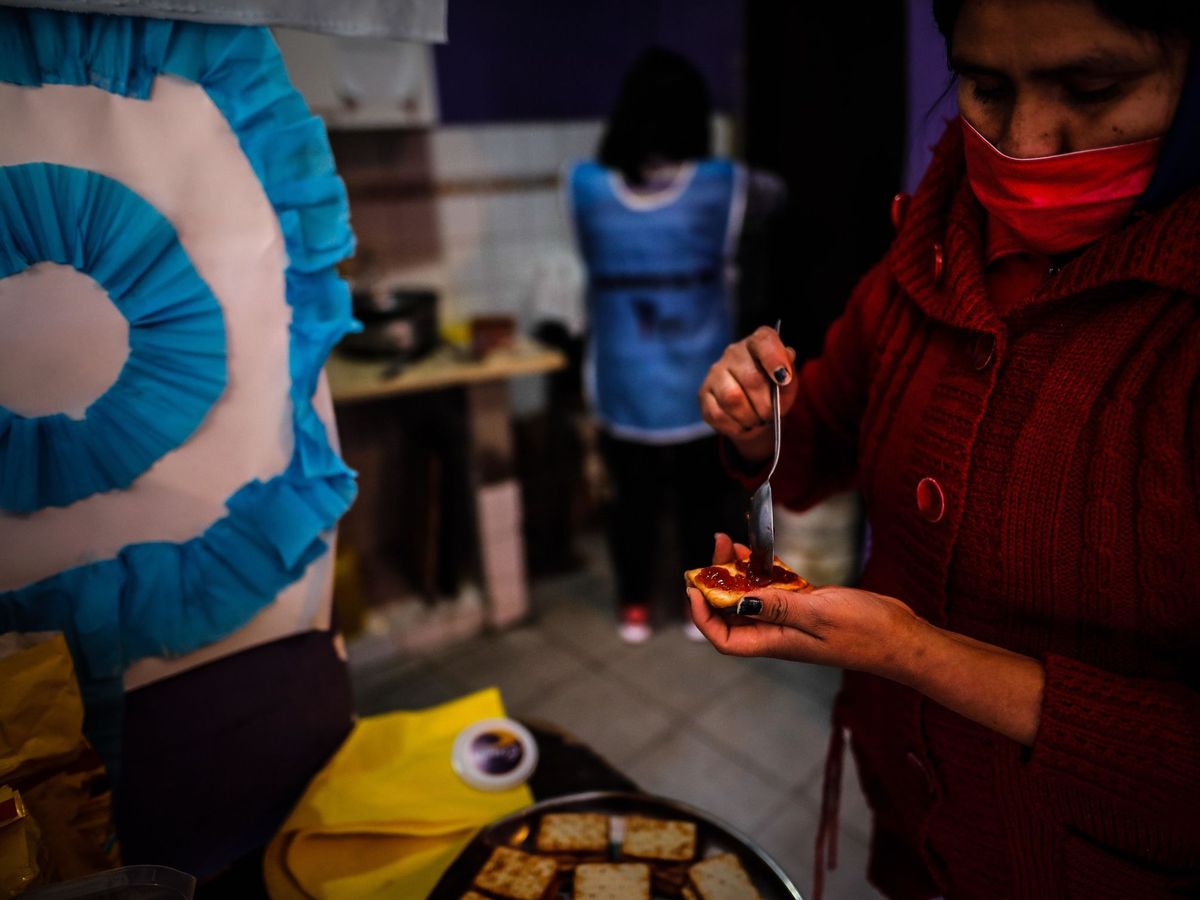Foto: Una mujer prepara galletas con mermelada para darle a niños en un comedor comunitario, el 29 de julio de 2020, en Buenos Aires (Argentina) (EFE)