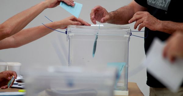Foto: Un miembro de una mesa electoral recoge papeletas de una urna durante las elecciones. (Reuters)