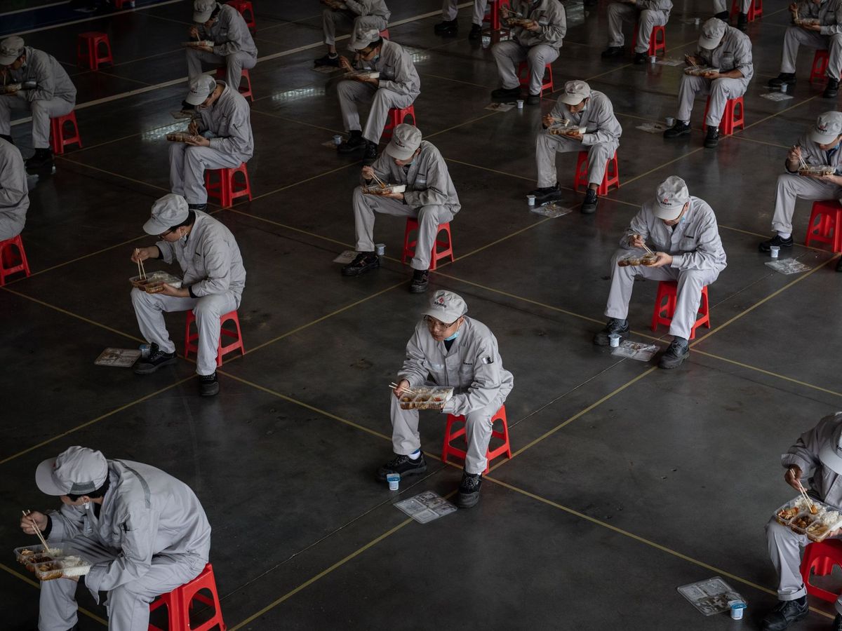 Foto: Trabajadores comen en asientos habilitados y colocados para mantener la distancia de seguridad. (EFE)