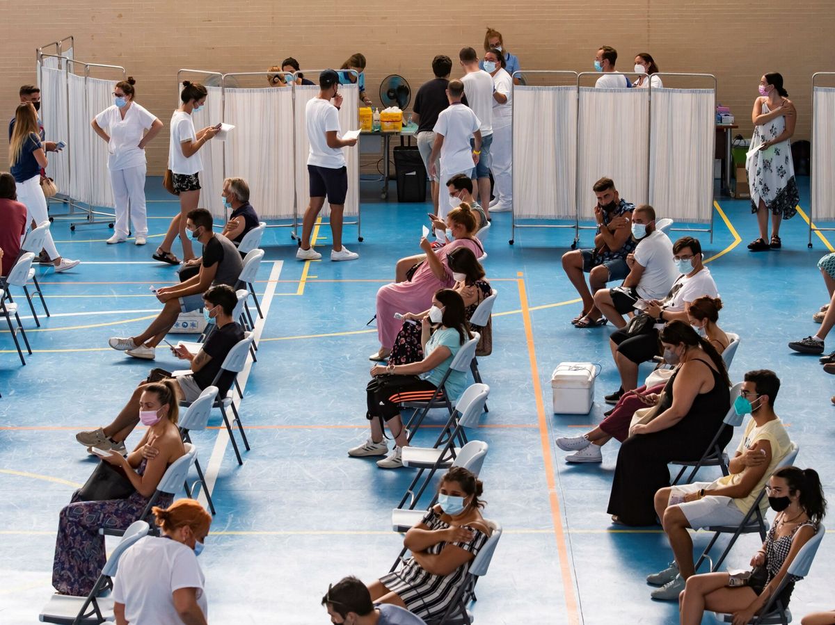 Foto: Varios jóvenes esperan tras recibir la vacuna en Espartinas, Sevilla. (EFE)