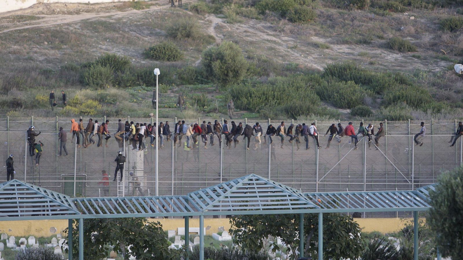 Foto: Inmigrantes en la valla de Melilla. (EFE)