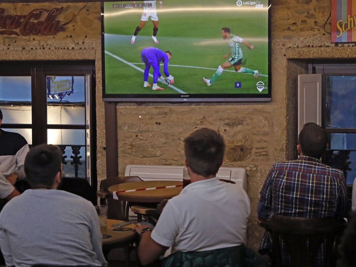 Foto: Aficionados siguen un partido de LaLiga desde un bar. (EFE/Lavandeira Jr))