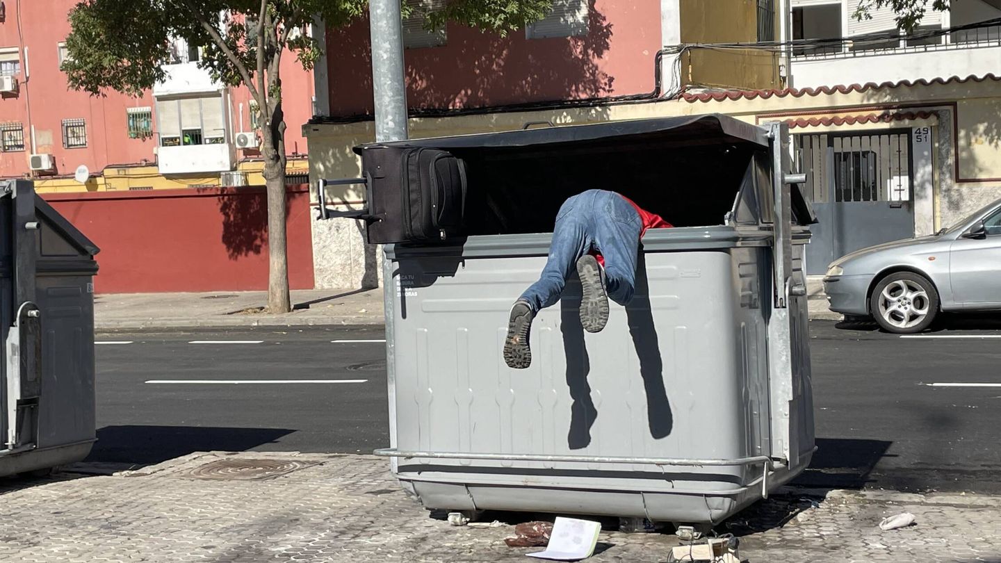 Un vecino rebusca en el interior de un contenedor de basura. (J. L. Losa)