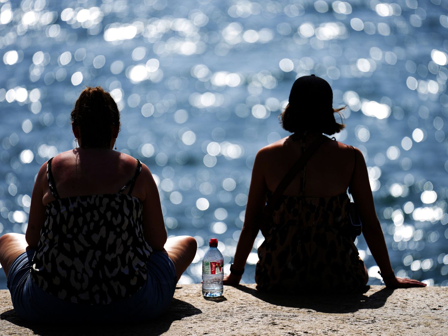 Dos personas observan el mar en la playa de la Barceloneta. (EFE/Alejandro García)