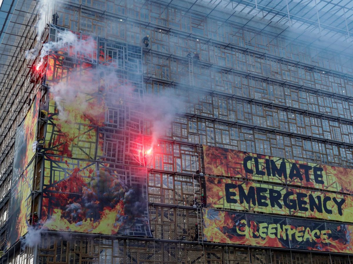 Foto: Activistas medioambientales cuelgan una pancarta gigante para anunciar la emergencia climática. (Reuters)