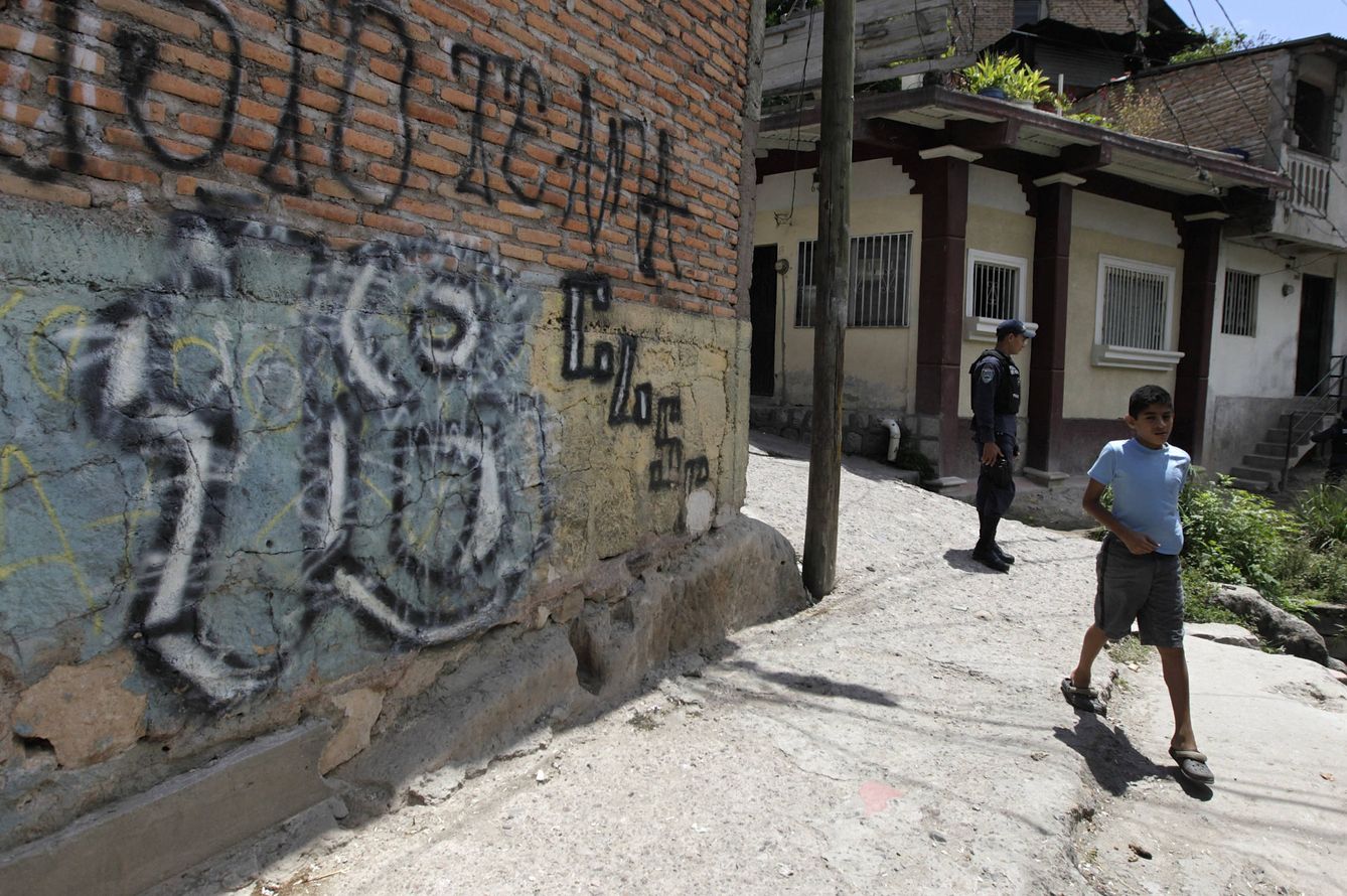 Un niño pasa ante una pintada de la Mara 18 en un barrio de Tegucigalpa. (Reuters) 