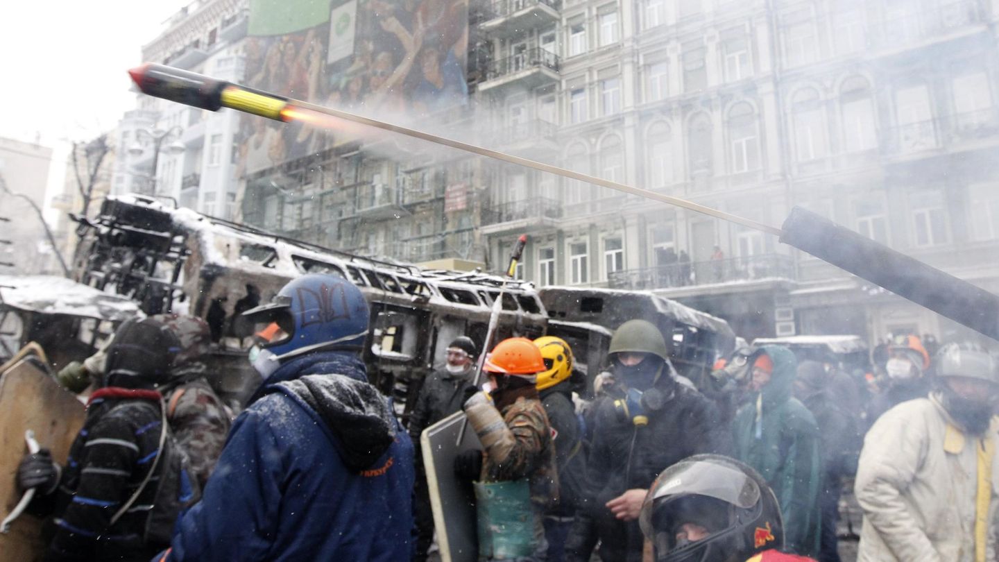 Manifestantes lanzan un proyectil pirotécnico contra la policía en Kiev (Reuters).