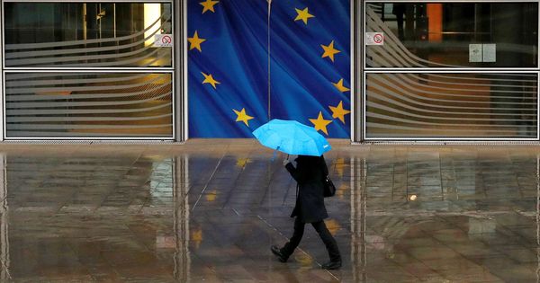 Foto: Una mujer pasea bajo la lluvia frente a la sede de la Comisión Europea. (Reuters)
