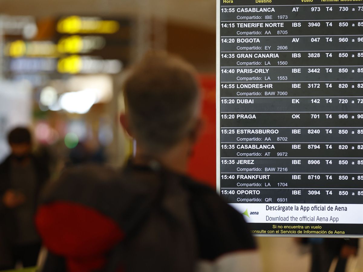 Foto: Un viajero revisa un panel de información en el Aeropuerto Adolfo Suárez Madrid-Barajas. (EFE/Mariscal)