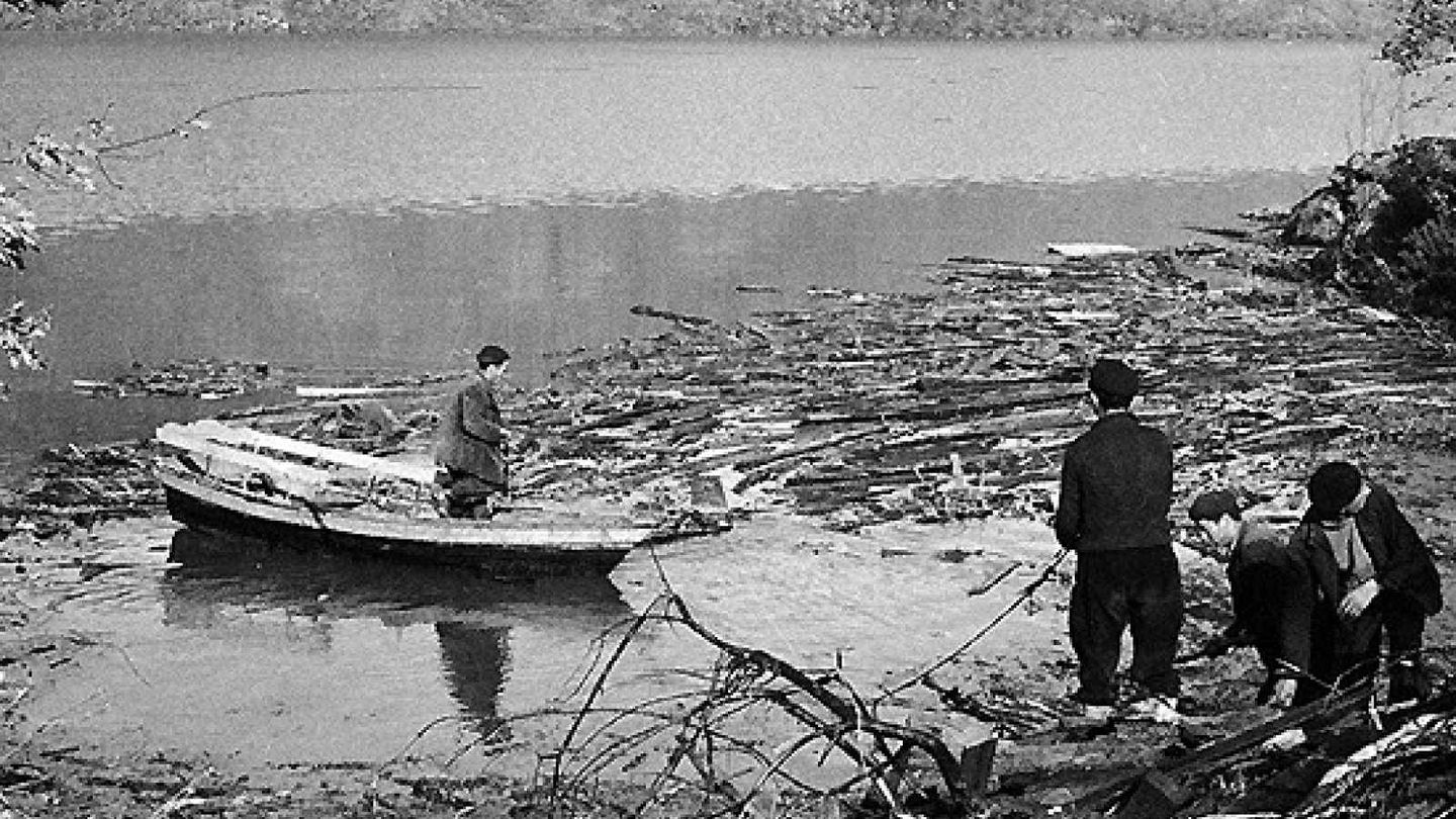Vecinos transitan los escombros del lago Sanabria con una barca. (EFE)