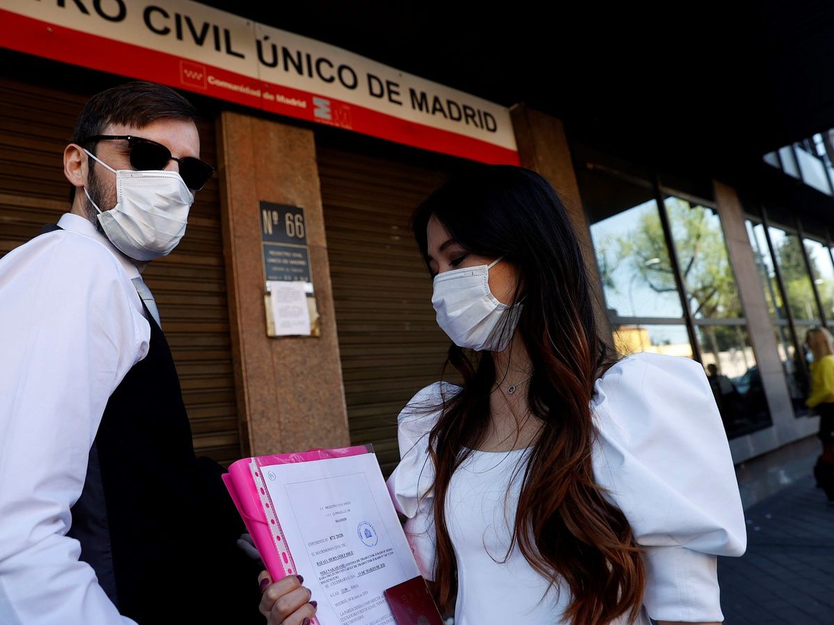 Foto: Una pareja espera para contraer matrimonio a las puertas del Registro Civil de Madrid, en plena pandemia. (EFE)