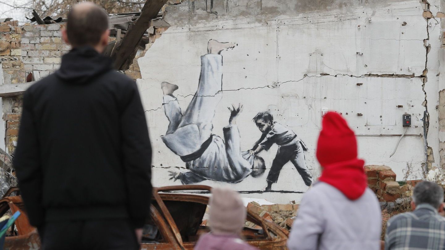 Dos niños delante de un mural pintado por Banksy en Kiev. (EFE/Sergey Dolzhenko)