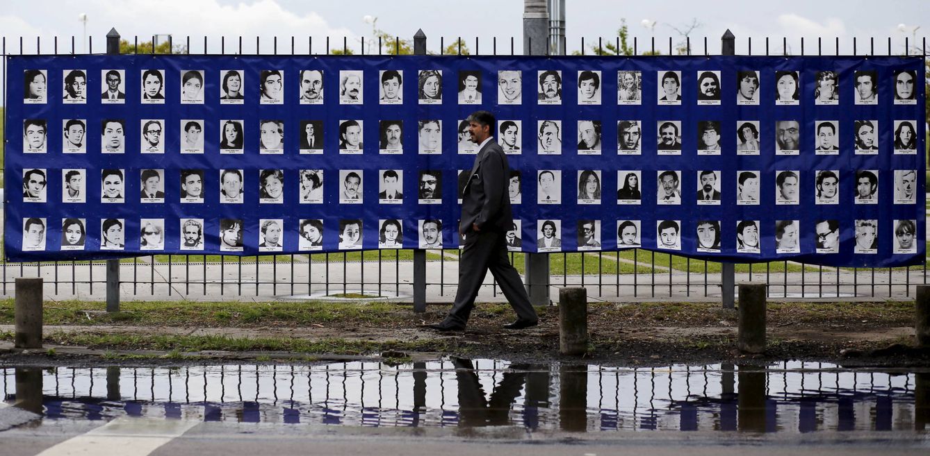 Un hombre pasa ante un cartel con imágenes de desaparecidos durante la dictadura, en Buenos Aires, el 18 de marzo de 2016 (Reuters). 